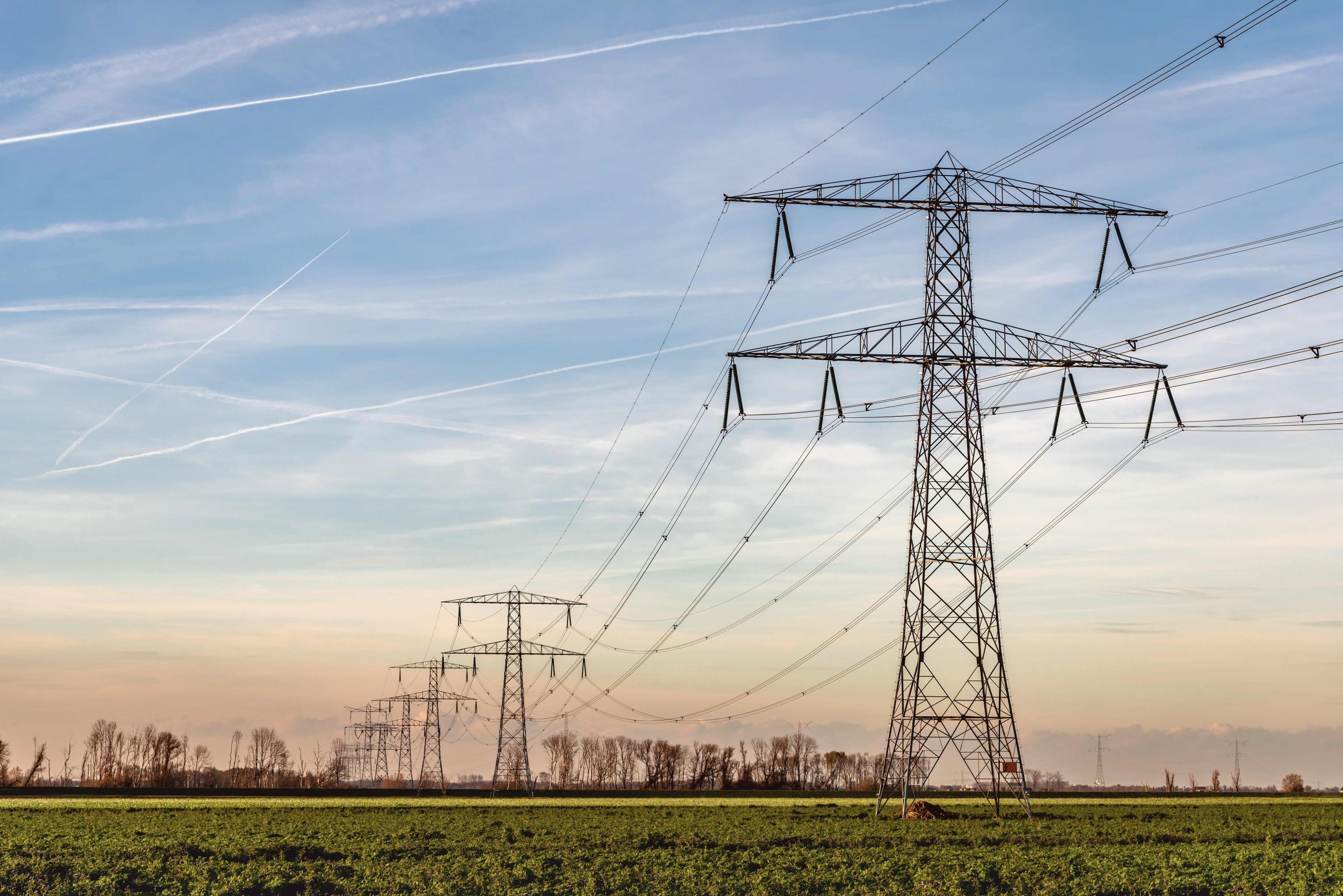 High voltage towers with thick hanging power cables in a rural l